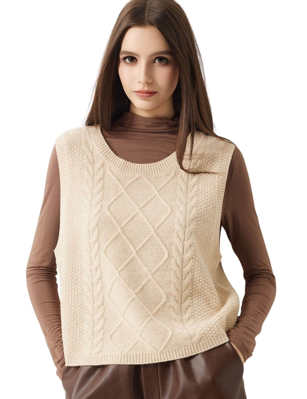 A woman modeling a cream-colored cable-knit sweater vest over a brown long-sleeve turtleneck top, set against a plain white background.