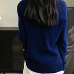 Woman wearing a 100% merino wool navy blue crewneck sweater, back view