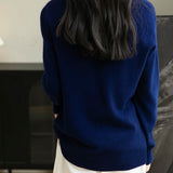 Woman wearing a 100% merino wool navy blue crewneck sweater, back view