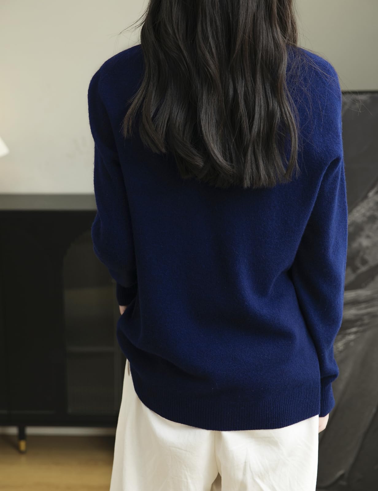 Woman wearing a 100% merino wool navy blue crewneck sweater, back view