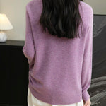 Woman wearing a 100% merino wool purple crewneck sweater, back view