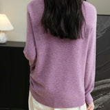 Woman wearing a 100% merino wool purple crewneck sweater, back view
