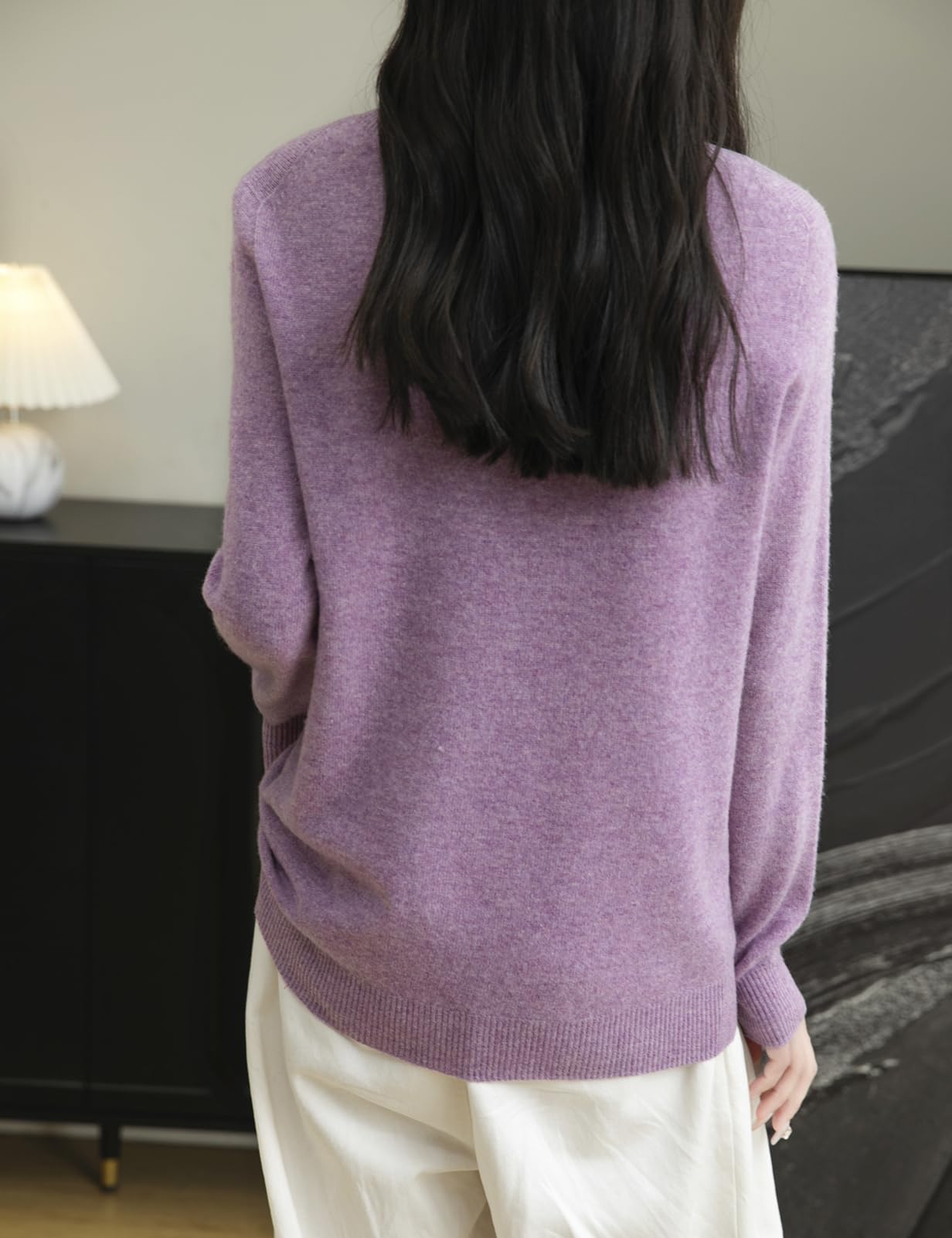 Woman wearing a 100% merino wool purple crewneck sweater, back view