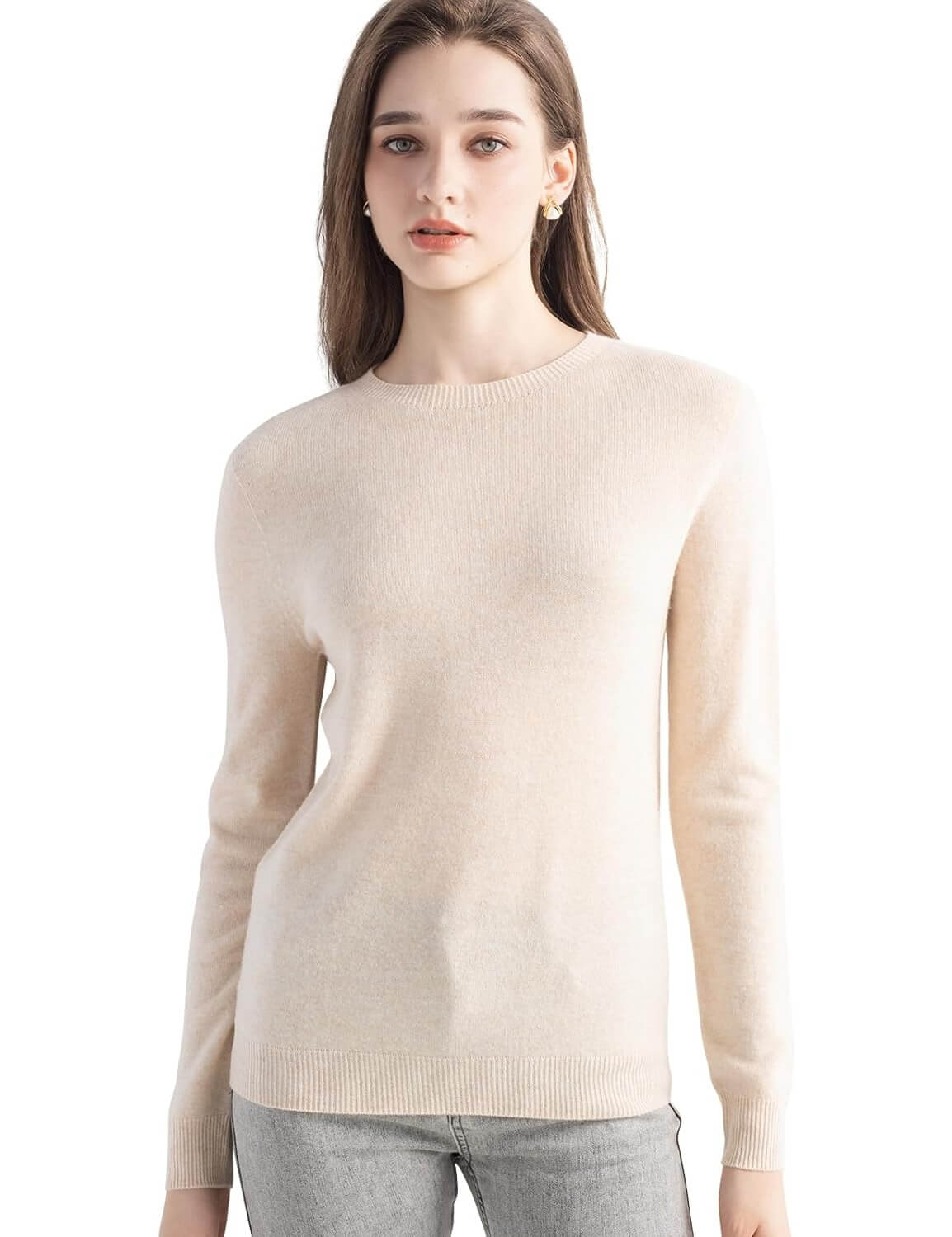 A woman wearing a long sleeve merino wool beige crewneck sweater.