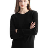 A woman wearing a long sleeve merino wool black crewneck sweater.