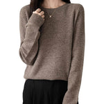 A woman wearing a long sleeve merino wool brown crewneck sweater.