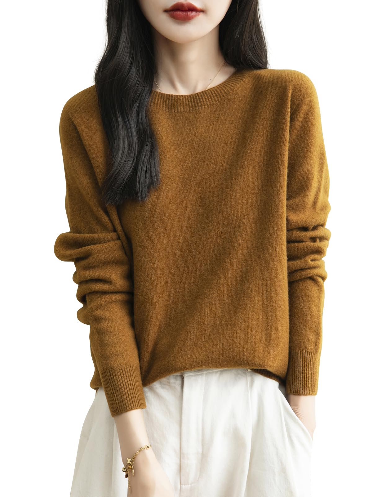 A woman wearing a long sleeve merino wool caramel crewneck sweater.