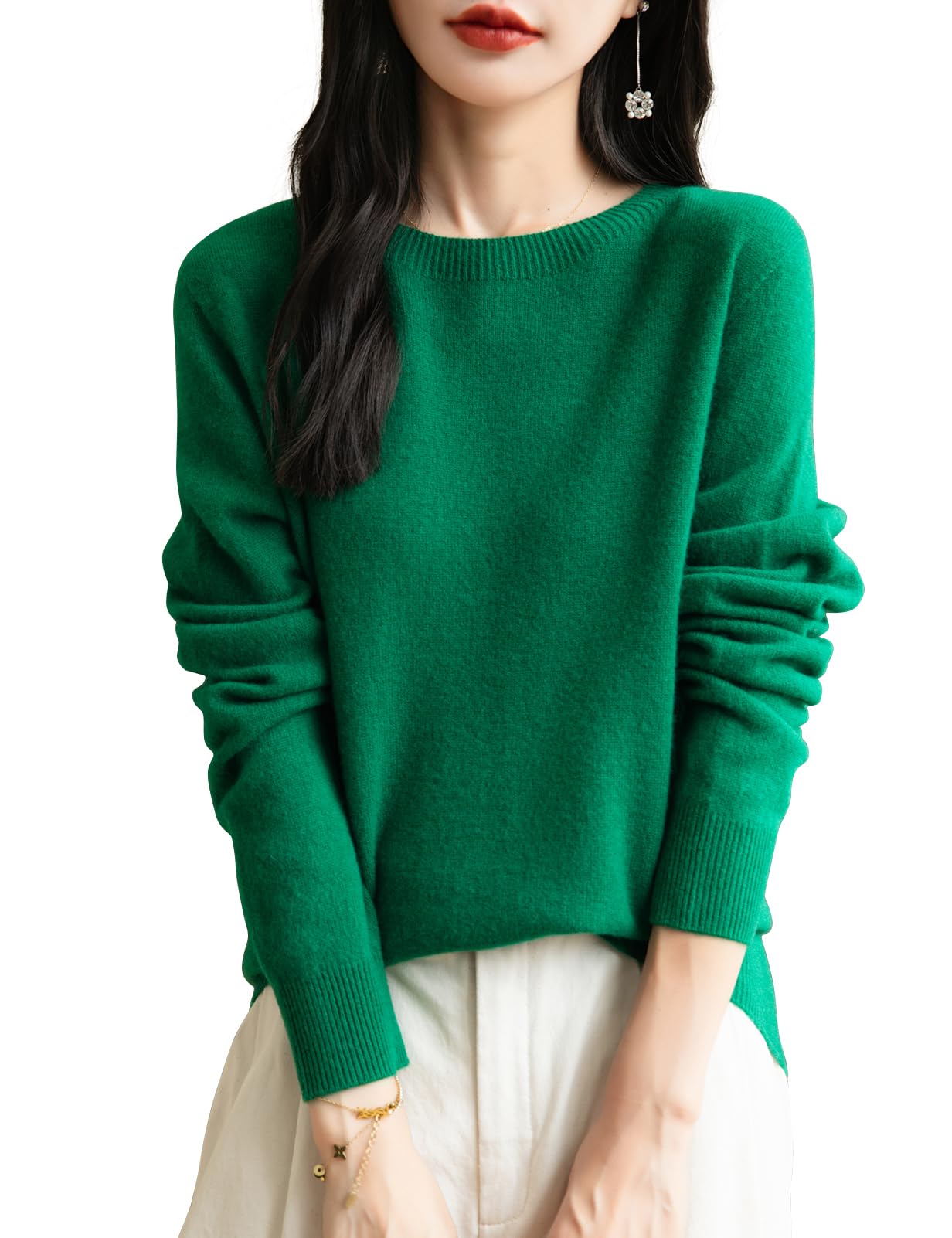 A woman wearing a long sleeve merino wool green crewneck sweater.