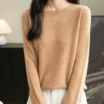 A woman wearing a long sleeve merino wool khaki crewneck sweater.