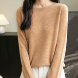 A woman wearing a long sleeve merino wool khaki crewneck sweater.