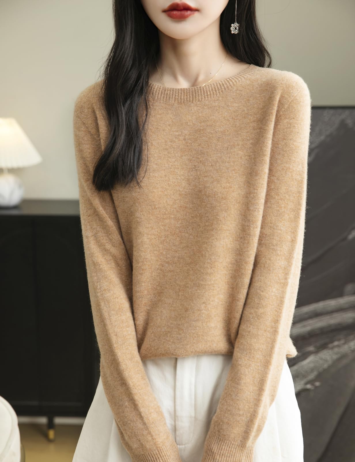 A woman wearing a long sleeve merino wool khaki crewneck sweater.