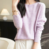 A woman wearing a long sleeve merino wool light purple crewneck sweater.