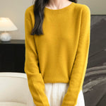 A woman wearing a long sleeve merino wool maple leaf crewneck sweater.
