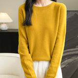 A woman wearing a long sleeve merino wool maple leaf crewneck sweater.
