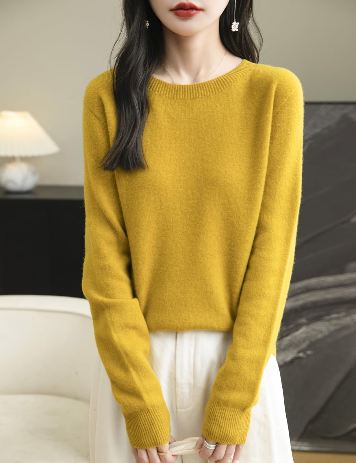 A woman wearing a long sleeve merino wool maple leaf crewneck sweater.