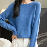 A woman wearing a long sleeve merino wool star blue crewneck sweater.