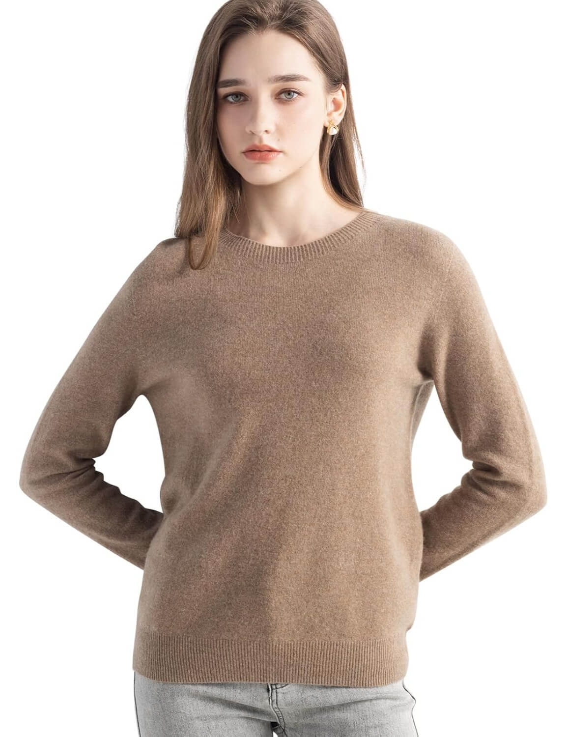 A woman wearing a long sleeve merino wool tan crewneck sweater.