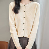 model wearing a women's beige merino wool crewneck cardigan sweater