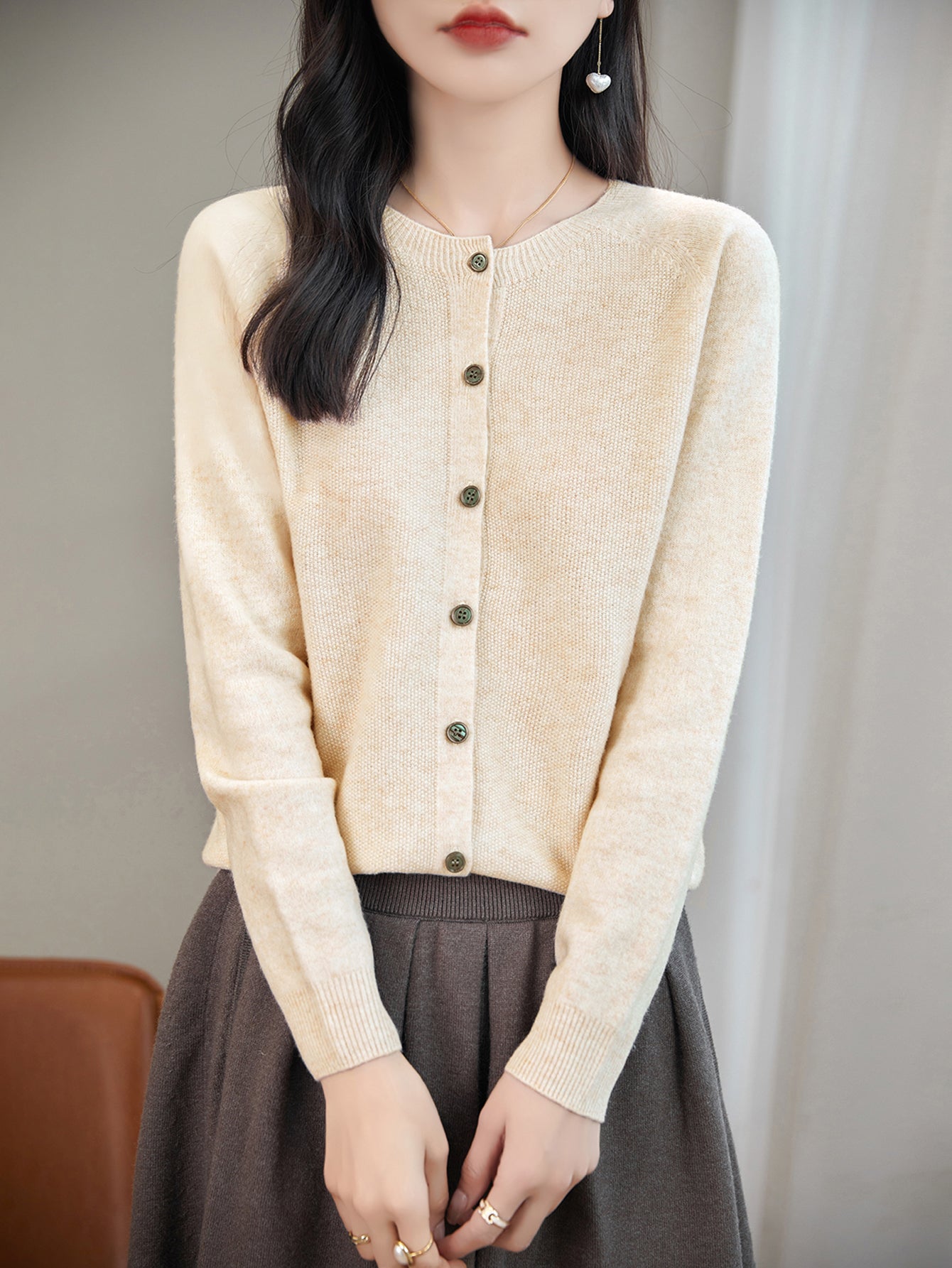 model wearing a women's beige merino wool crewneck cardigan sweater